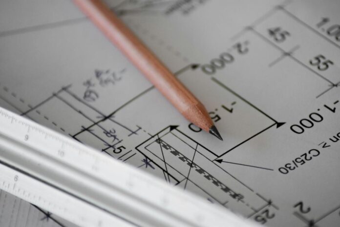 Pencil resting on architectural drawings for a home renovation
