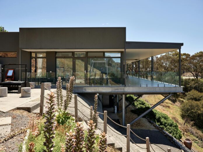 Modern house with glazed outdoor space overlooking a mountain landscape